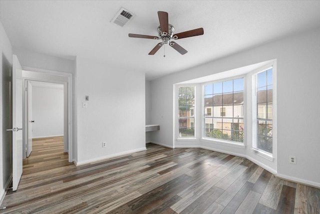 unfurnished room featuring ceiling fan and dark hardwood / wood-style flooring