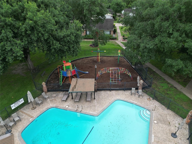 view of swimming pool featuring a playground and a yard