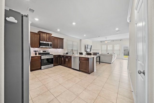 kitchen featuring sink, stainless steel appliances, a barn door, and dark brown cabinetry