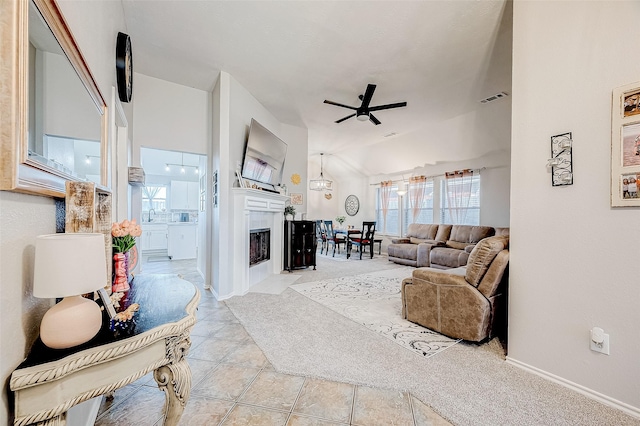 tiled living room featuring ceiling fan and vaulted ceiling