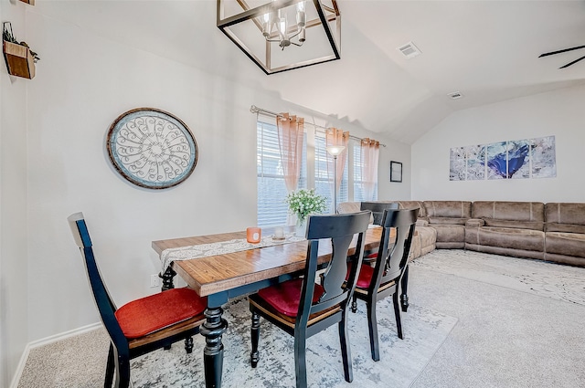 carpeted dining room with lofted ceiling and ceiling fan with notable chandelier