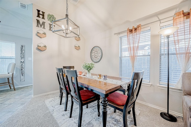 dining space with light colored carpet and a chandelier