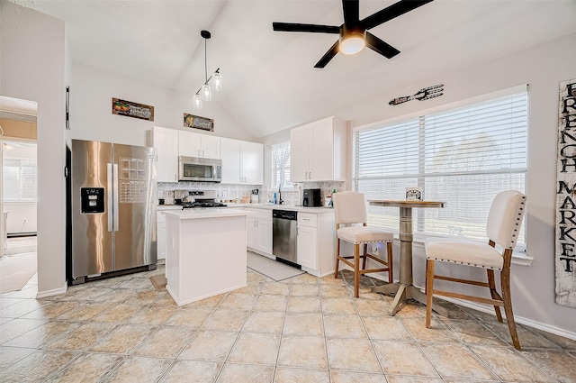 kitchen with white cabinetry, backsplash, hanging light fixtures, and appliances with stainless steel finishes