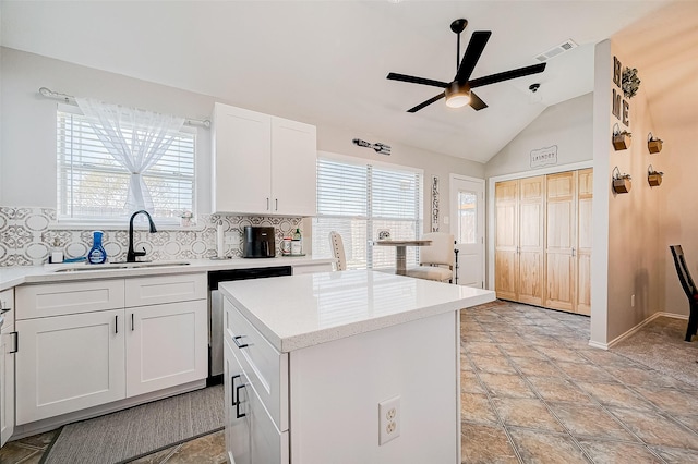 kitchen with a center island, tasteful backsplash, white cabinets, ceiling fan, and sink