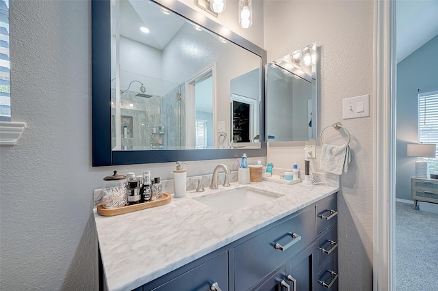 bathroom with a tile shower and vanity