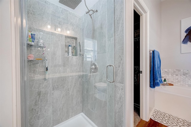 bathroom with hardwood / wood-style flooring and walk in shower