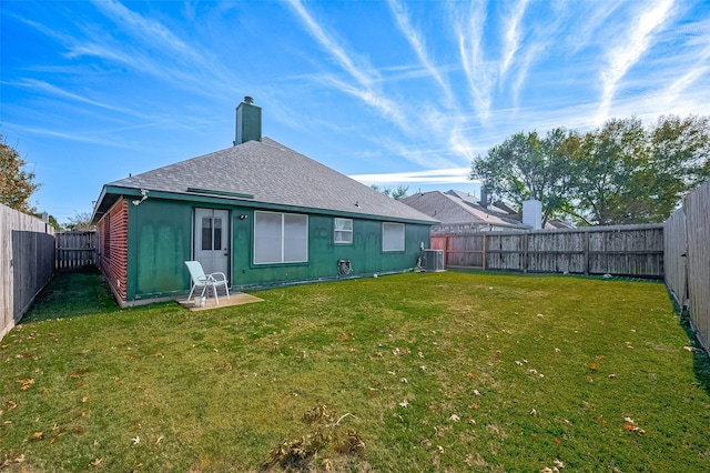 rear view of property featuring a yard and central AC