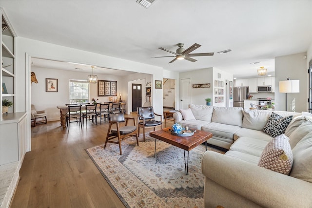 living room with dark wood-type flooring and ceiling fan