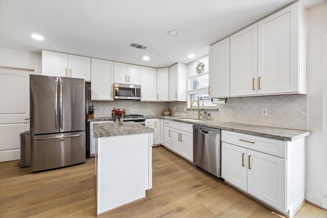 kitchen with sink, white cabinetry, appliances with stainless steel finishes, and a kitchen island