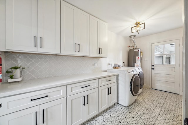 laundry room featuring water heater, cabinets, and separate washer and dryer