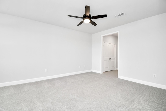 carpeted empty room with baseboards, visible vents, and ceiling fan