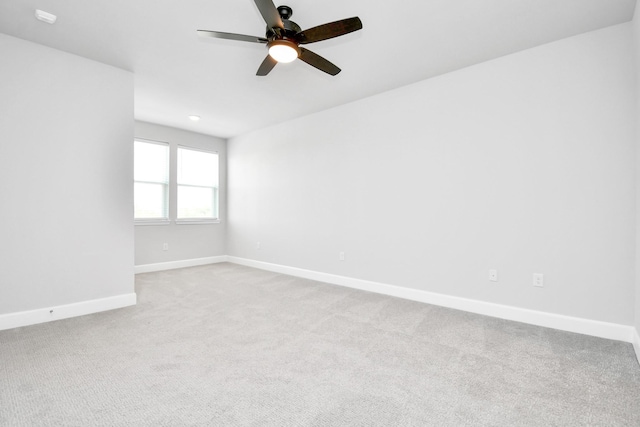 unfurnished room with a ceiling fan, baseboards, and carpet flooring