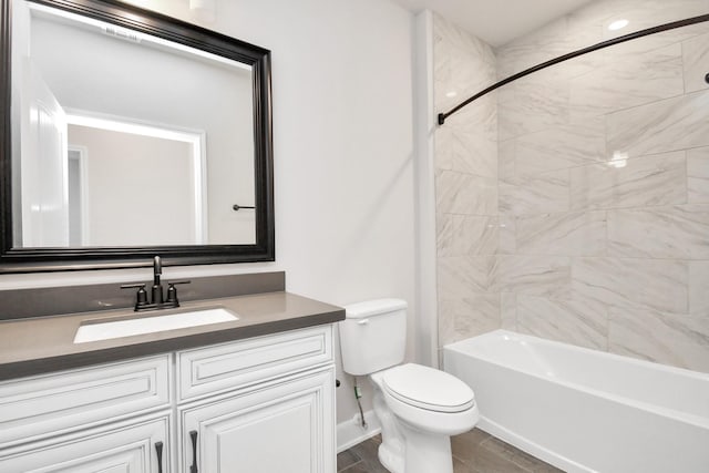 full bathroom featuring bathing tub / shower combination, toilet, vanity, wood finished floors, and baseboards