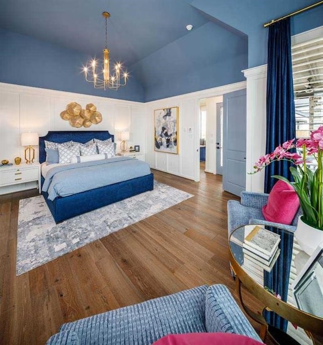 bedroom with high vaulted ceiling, a chandelier, and hardwood / wood-style flooring