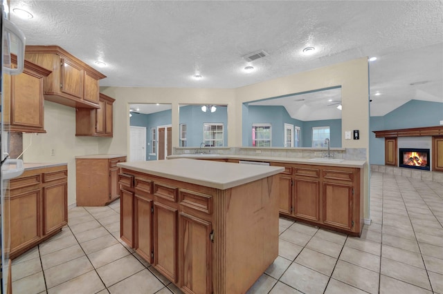 kitchen with a kitchen island, an inviting chandelier, sink, kitchen peninsula, and vaulted ceiling