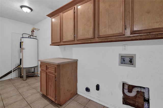 washroom featuring water heater, washer hookup, a textured ceiling, light tile patterned floors, and cabinets