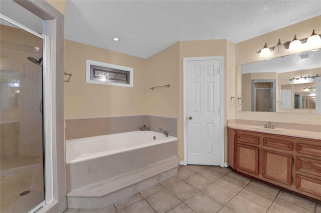 bathroom with plus walk in shower, a textured ceiling, tile patterned floors, and vanity