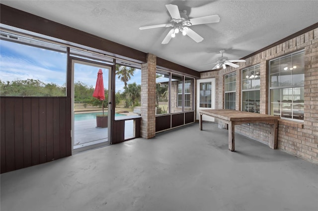 unfurnished sunroom featuring ceiling fan