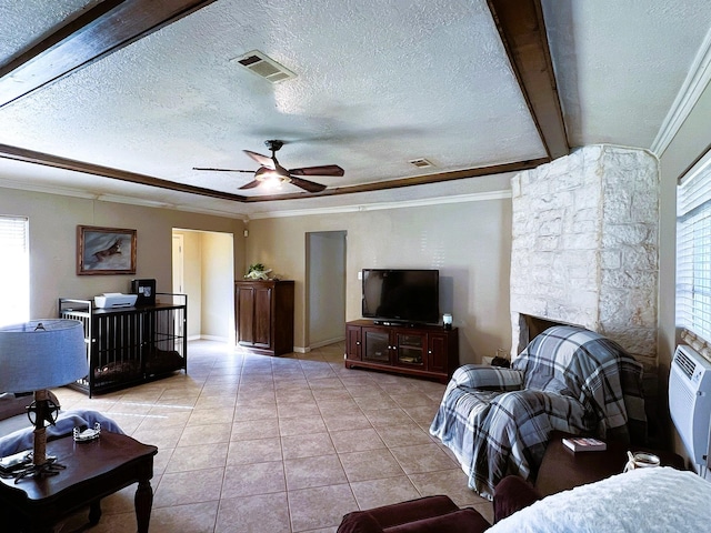 tiled living room with a fireplace, a textured ceiling, ceiling fan, and crown molding