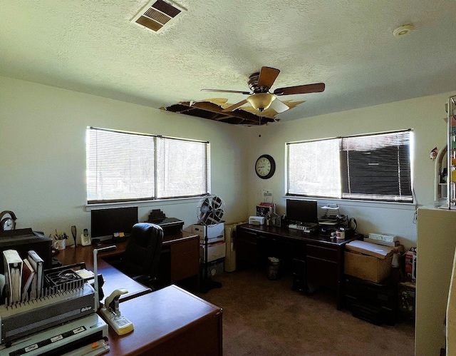 carpeted office featuring a textured ceiling and ceiling fan