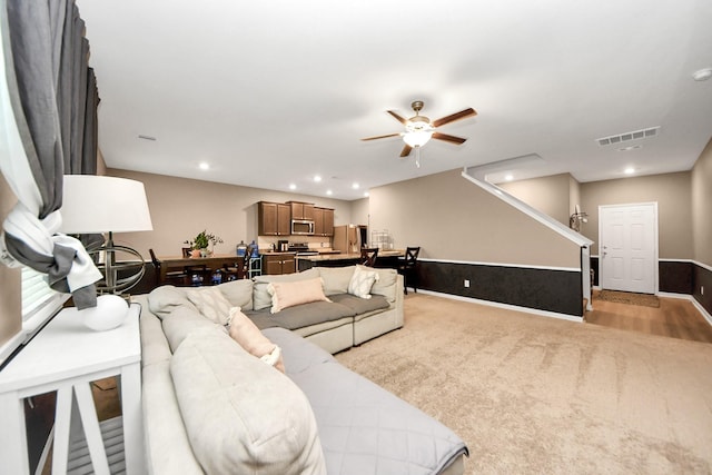 carpeted living room featuring ceiling fan