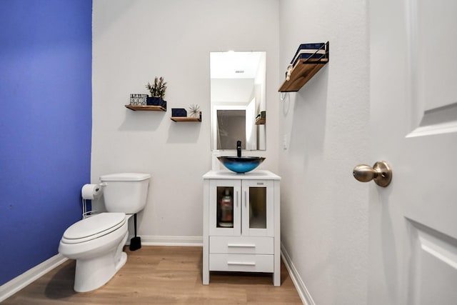 bathroom featuring toilet, vanity, and hardwood / wood-style floors