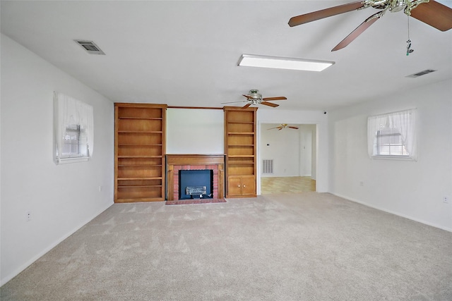 unfurnished living room with ceiling fan, light colored carpet, and a fireplace