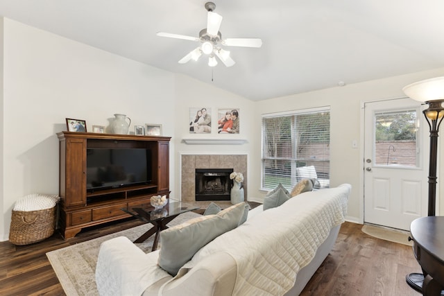 living room with lofted ceiling, a tiled fireplace, ceiling fan, and dark hardwood / wood-style flooring