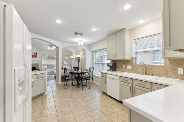 kitchen featuring white appliances, light tile patterned floors, tasteful backsplash, ceiling fan, and sink