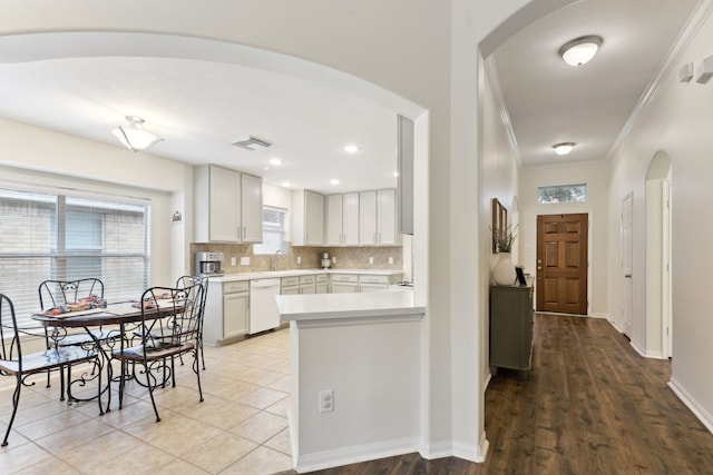 kitchen with sink, white cabinetry, dishwasher, decorative backsplash, and crown molding