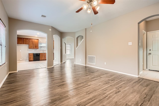 unfurnished living room featuring sink, ceiling fan, and light hardwood / wood-style flooring