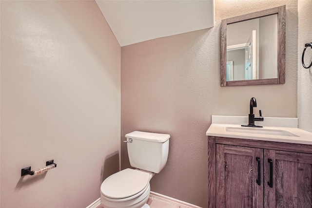 bathroom featuring lofted ceiling, vanity, and toilet