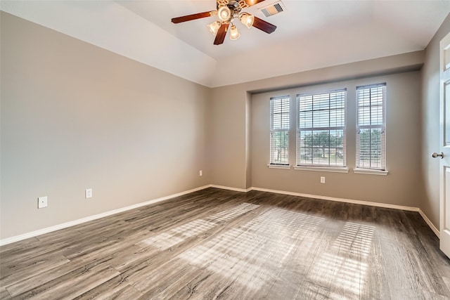 unfurnished room featuring ceiling fan, a tray ceiling, lofted ceiling, and hardwood / wood-style flooring