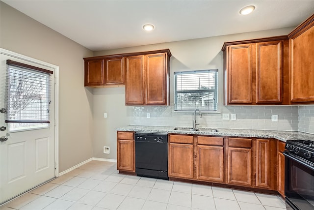 kitchen featuring light stone counters, light tile patterned floors, black appliances, decorative backsplash, and sink