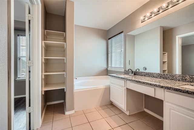 bathroom with a bath, tile patterned floors, and vanity