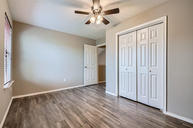 unfurnished bedroom with ceiling fan, a closet, and hardwood / wood-style flooring