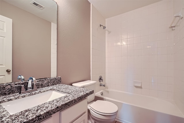 full bathroom with toilet, tiled shower / bath combo, and vanity