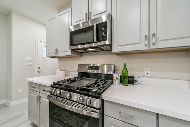 kitchen with appliances with stainless steel finishes and light hardwood / wood-style flooring