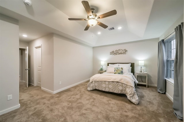 bedroom featuring carpet, ceiling fan, and a tray ceiling