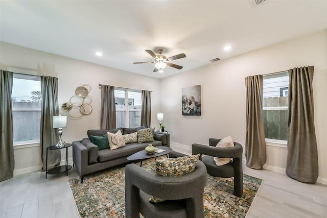 living room with ceiling fan and light hardwood / wood-style flooring