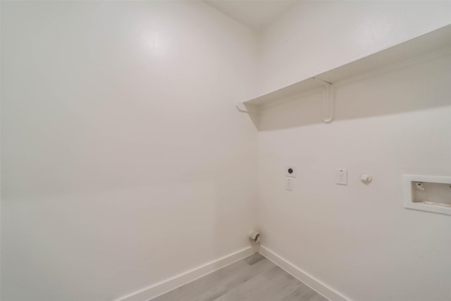 washroom with hookup for a washing machine, hookup for an electric dryer, light hardwood / wood-style flooring, and gas dryer hookup