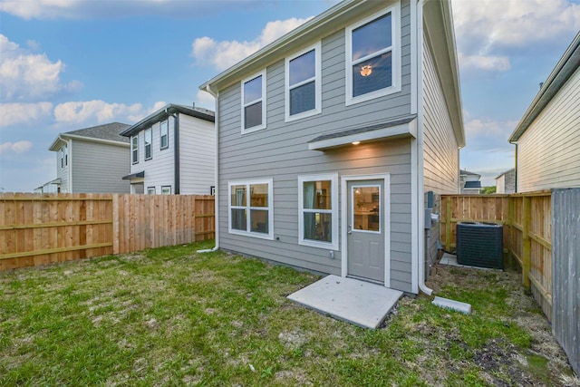 back of property with cooling unit and a lawn