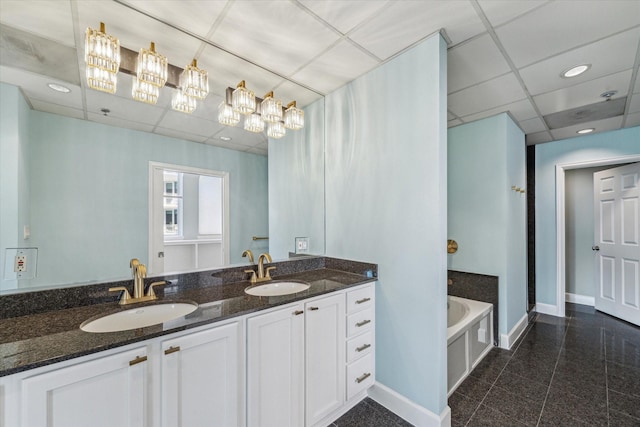 bathroom featuring a washtub, vanity, and a paneled ceiling