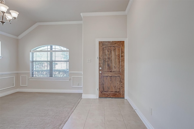 tiled entryway featuring lofted ceiling, an inviting chandelier, and ornamental molding