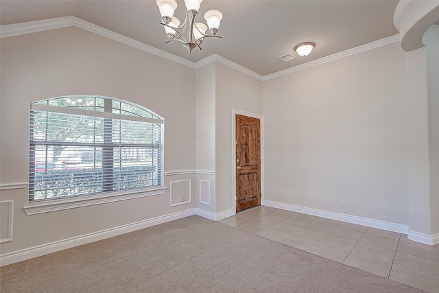 spare room featuring ornamental molding, light tile patterned flooring, and a chandelier