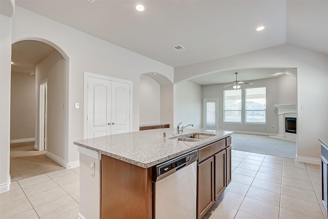 kitchen featuring sink, light tile patterned flooring, ceiling fan, stainless steel dishwasher, and a kitchen island with sink