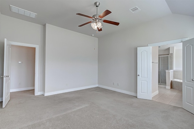 unfurnished bedroom with ceiling fan, ensuite bathroom, vaulted ceiling, and light carpet