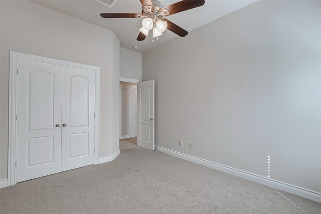 unfurnished bedroom featuring ceiling fan, light colored carpet, and a closet