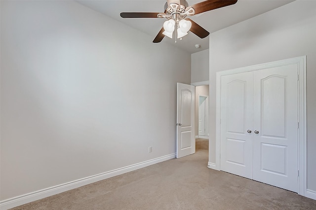 unfurnished bedroom featuring light carpet, a closet, and ceiling fan