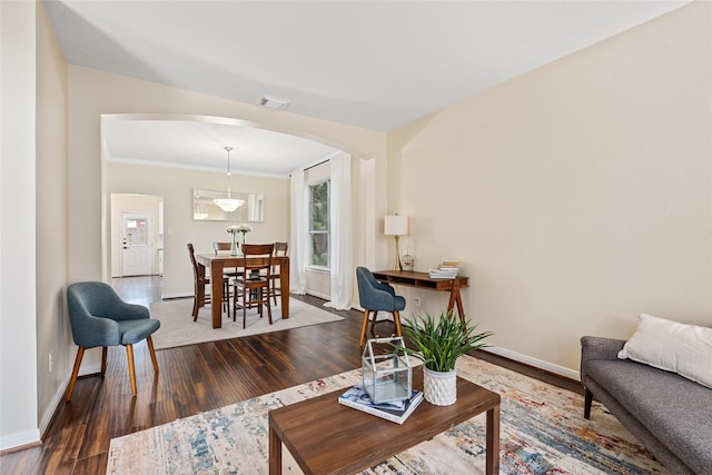 living room with dark hardwood / wood-style flooring and ornamental molding